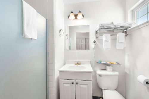 a white bathroom with a sink and a toilet at Quality Inn & Suites in Jackson