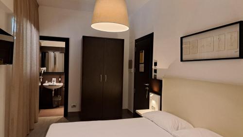 a bedroom with a bed and a bathroom with a sink at LH Hotel Excel Roma Montemario in Rome