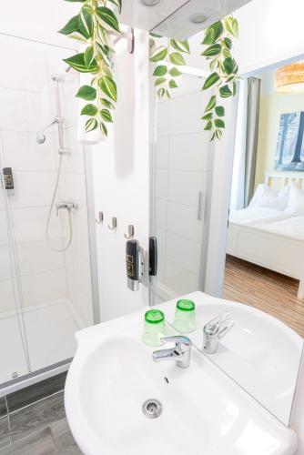 a bathroom with a white sink and a shower at Hotel Schönbrunn by Vienna Living Apartments in Vienna
