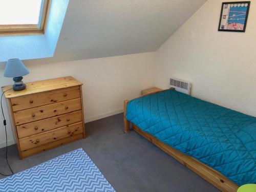 une chambre avec un lit et une commode en bois dans l'établissement Appartement centre- plage 500 m-3 chambres pour 6 personnes, à Pornichet