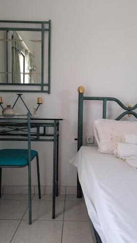 a bedroom with a bed and a desk with a mirror at Ekatis Seacoast Nest in Livanátai