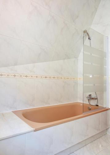 a bath tub in a bathroom with white tiles at Enorme TRIPLEX en el centro de O Grove in O Grove