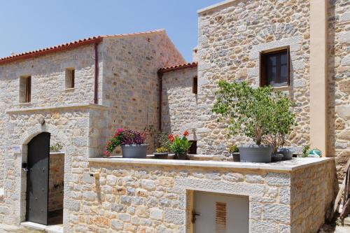 a stone building with potted plants on a ledge at Sun Villa in Neon Oitilon