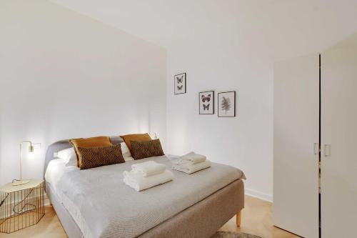 une chambre blanche avec un lit avec des serviettes dessus dans l'établissement Welcoming apartment - 2BR-4P - Arc de Triomphe, à Paris
