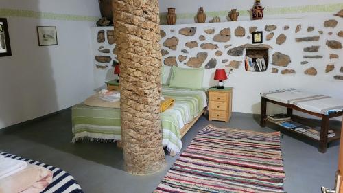 a room with a bed and a pole in it at Tigmi Bulbul in Id AÃ¯ssa