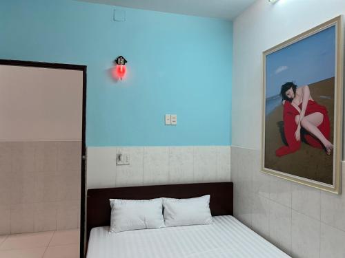 a bedroom with a bed with a picture on the wall at Bin Hom Motel in Bien Hoa