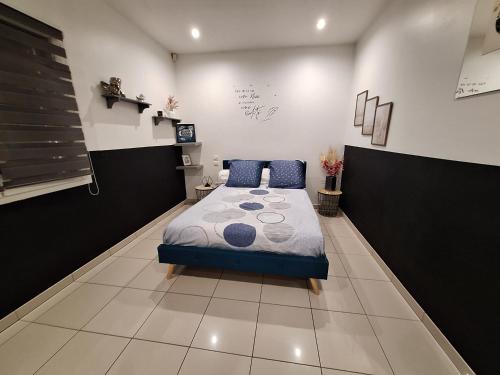 une chambre avec un lit avec des oreillers bleus dessus dans l'établissement IDEAL POUR VOS VACANCES, à Espondeilhan