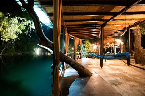 a house with a tree growing out of the water at Riverside Cabin in Čapljina