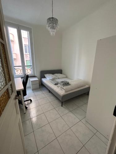 une chambre avec un lit, un bureau et une fenêtre dans l'établissement 150 m de la plage des catalans, à Marseille