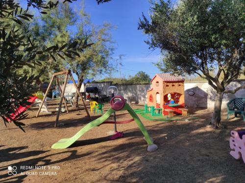 a playground with a slide and a swing set at Appartamento in residence a Campomarino di Maruggio in Maruggio