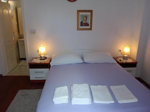 a bedroom with a large bed with two lamps on two tables at A1 Studio in Bol