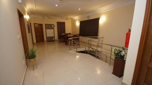 a living room with a staircase and a dining room at World Inn by WI Hotel in Karachi