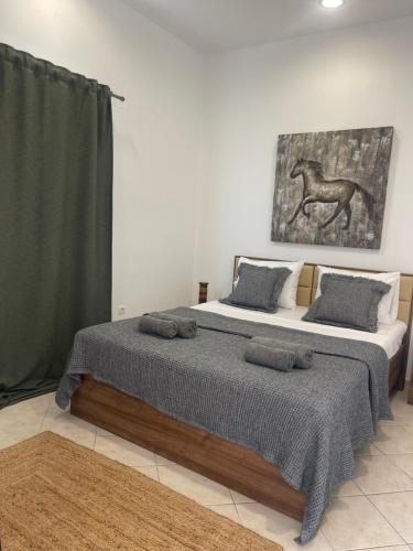 two beds in a room with a picture of a horse at Agroktima Drosou Apartment in Ancient Epidavros