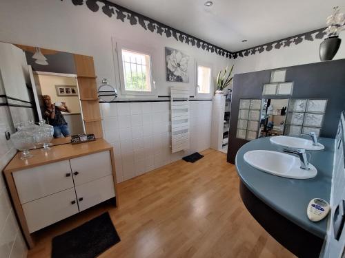 une femme prenant une photo d'une salle de bains dans l'établissement IDEAL POUR VOS VACANCES, à Espondeilhan