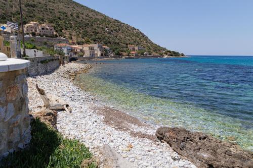 a rocky beach with houses and the water at Sun Villa in Neon Oitilon