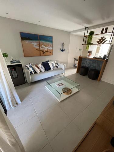 a living room with a couch and a glass table at Imperia Lounge Itacimirim in Camacari