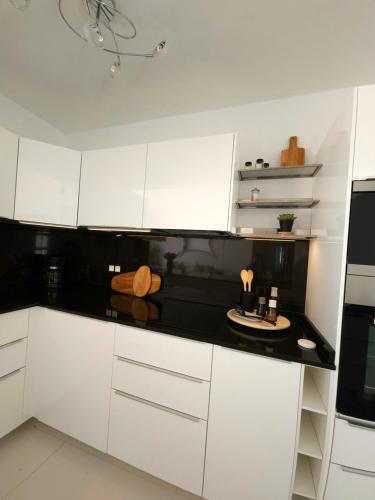 a kitchen with white cabinets and a black counter top at Blue Miracle Villa in Arrecife