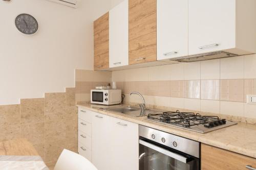 a kitchen with a stove and a microwave at Cuore di Conchiglia 3 in Custonaci