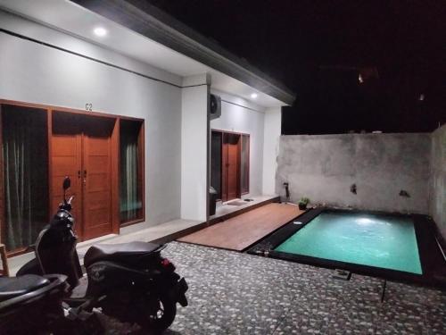 Pondok Giri 3 في جيمباران: حمام سباحة في غرفة مع كلب يجلس بجانبه