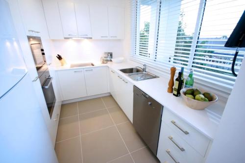 a kitchen with a sink, stove, and dishwasher at Domain Serviced Apartments in Brisbane