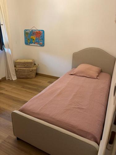 - un petit lit dans une chambre avec un cadre de lit dans l'établissement Maison avec piscine, à Saint-Mathieu-de-Tréviers