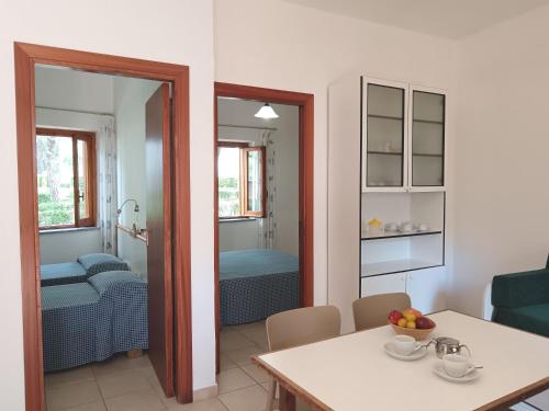 a living room with a table and a bedroom at Villaggio Turistico La Mantinera - Residence in Praia a Mare