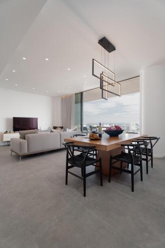 a dining room with a table and chairs and a couch at Protaras Eden Seaside Suite in Protaras