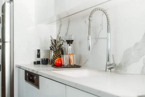 a kitchen counter with a sink and a faucet at Protaras Eden Seaside Suite in Protaras