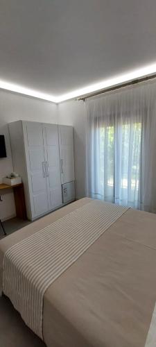 a white bedroom with a large bed and a window at ArteMare B&B in Diamante