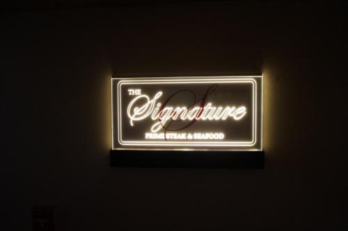 a neon sign that says the adventure hotel and banquet at LSI Resorts at Ala Moana in Honolulu