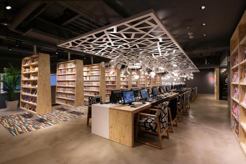 東京にあるブース ネットカフェ & カプセルの大きな部屋で、長いテーブル(コンピュータ付)が備わります。