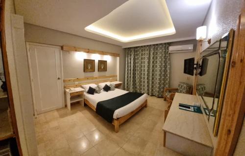 a hotel room with a bed and a television at Beau Site Hotel in Marsa Matruh