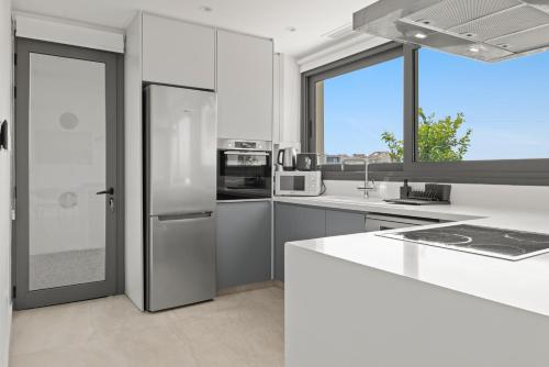 a white kitchen with a refrigerator and a sink at Serenity Waves Villa 10 in Sophtadhes