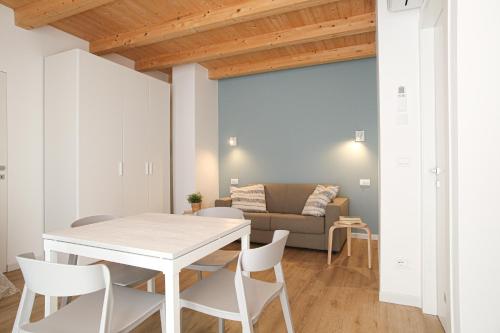 a living room with a table and chairs and a couch at ALOE Comfort Rooms in Pescara