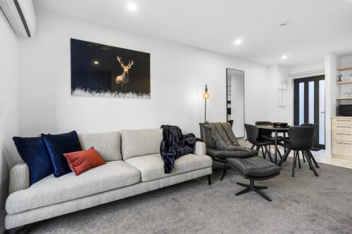 a living room with a couch and a table at Stylish and Sleek City Stay in Christchurch