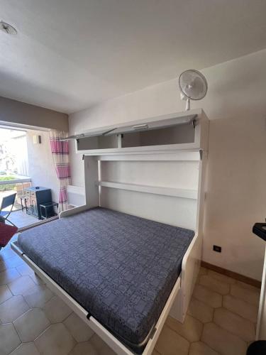 - un lit dans une chambre avec des étagères dans l'établissement Charmant studio à 20 m de la plage - 2BEAZUR99, à Canet
