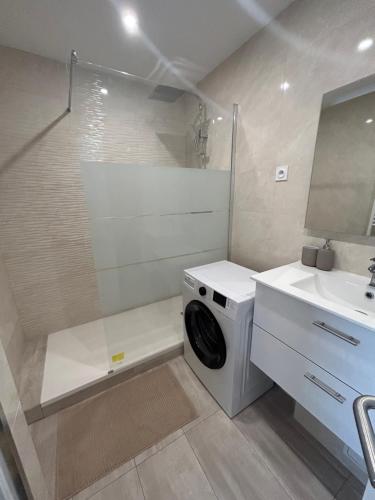 une salle de bain avec une machine à laver et un lavabo dans l'établissement Plage, stade et parking privé dans la résidence, à Marseille