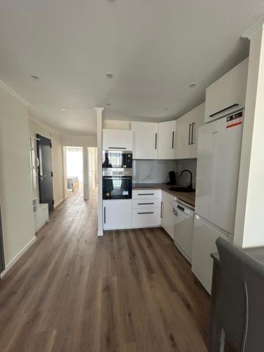 une cuisine avec des armoires blanches et un plancher en bois dans l'établissement Plage, stade et parking privé dans la résidence, à Marseille