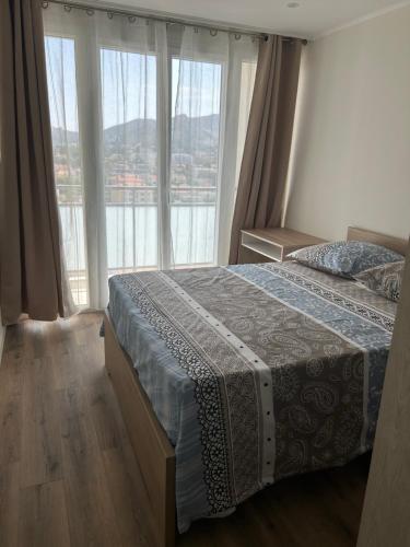 une chambre avec un lit et une grande fenêtre dans l'établissement Plage, stade et parking privé dans la résidence, à Marseille