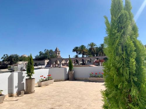 a courtyard with a white fence and two trees and flowers at Yanahuara La Casa del Angel in Yanahuara