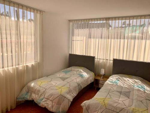 a bedroom with two beds and a window at Yanahuara La Casa del Angel in Yanahuara