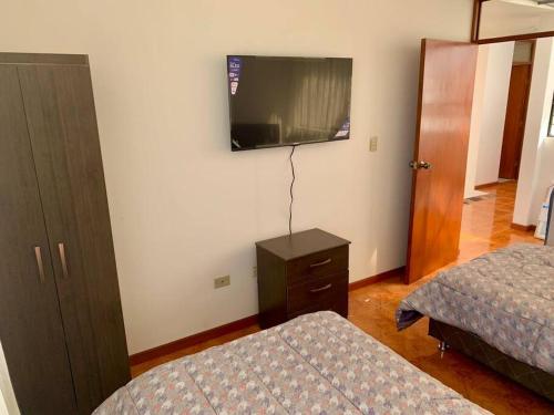 a bedroom with two beds and a flat screen tv at Yanahuara La Casa del Angel in Yanahuara