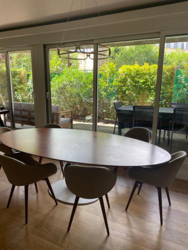 une table et des chaises dans une pièce avec piano dans l'établissement Superbe appartement refait avec terrasse, à Neuilly-sur-Seine
