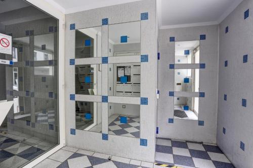 Cette chambre est dotée de carrelage bleu et blanc sur le mur. dans l'établissement La Marguerite - Guyancourt, à Guyancourt