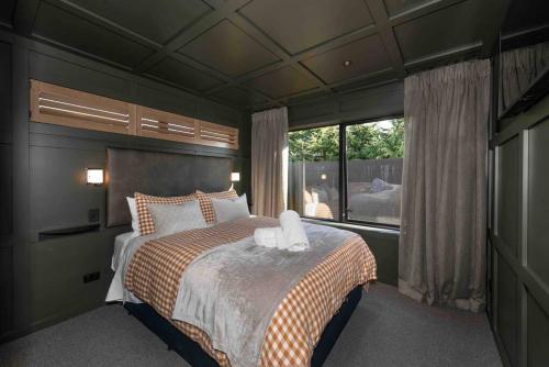 Un dormitorio con una cama grande y una ventana. en Yellow Pots Apartment A, Luxurious Outdoor Bath, en Wanaka
