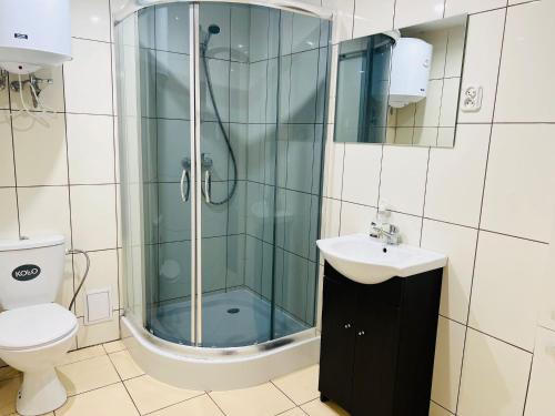 ein Badezimmer mit Dusche, Waschbecken und Toilette in der Unterkunft Del sol in Pogorzelica