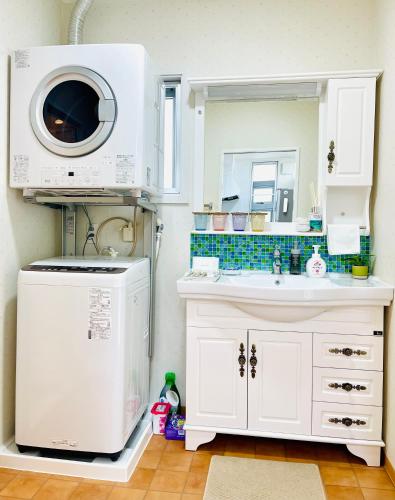a kitchen with a microwave and a sink at Sunset Beach Vacation House in Chatan