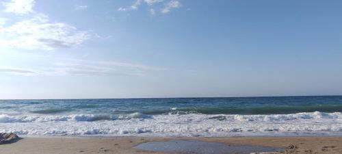 a beach with waves and the ocean at Sea Harmony in Adelianos Kampos