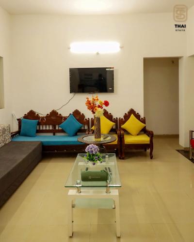 a living room with a couch and a table at Thai Stays Villa in Shenwa