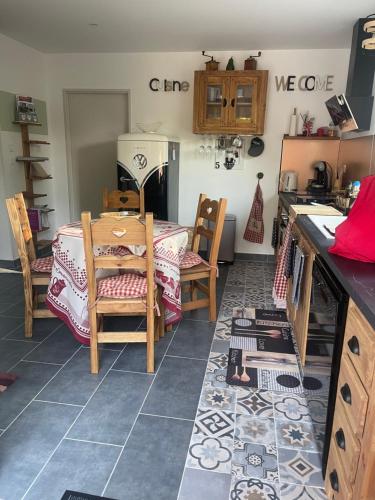 une cuisine avec une table et des chaises dans une pièce dans l'établissement Un jardin en forêt, à Samois-sur-Seine